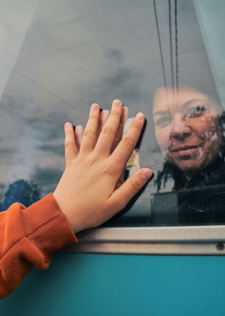 A touching moment captured of a hand on a train window, symbolizing farewell and emotion.
